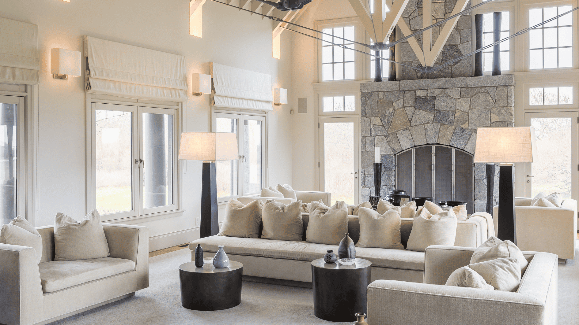 spacious coastal living room in obama martha vineyard home with vaulted ceiling stone fireplace neutral tones big window