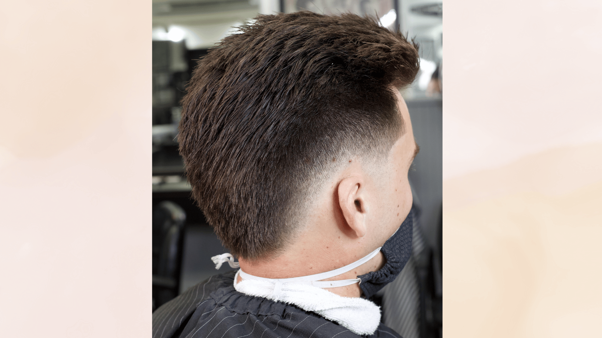 low mohawk haircut with subtle faded sides and short textured top creating a clean modern appearance