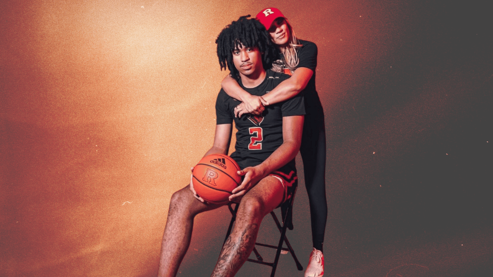 Maria Pizarro Harper embraces Dylan Harper as he holds a basketball in a Rutgers-themed portrait.