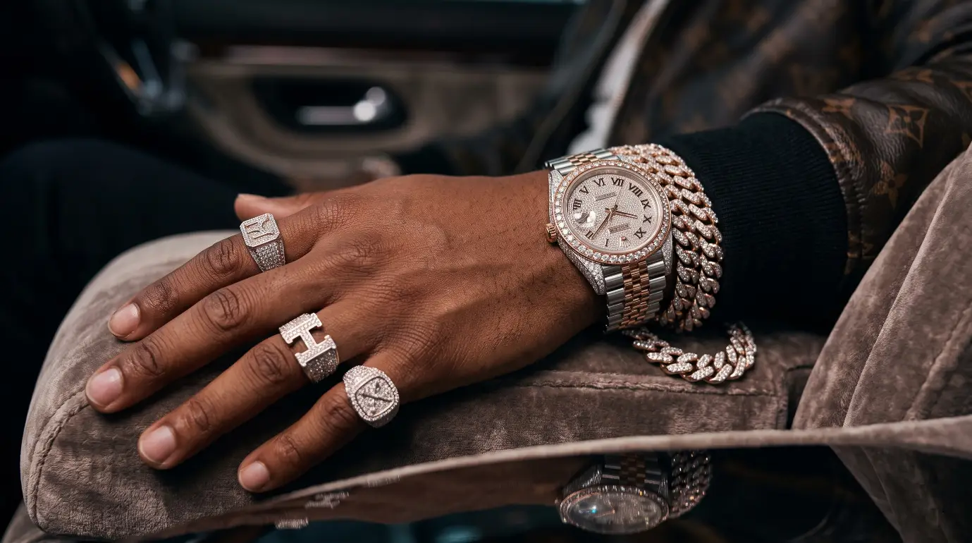 Close-up of hand wearing diamond-studded watch and rings on plush car interior