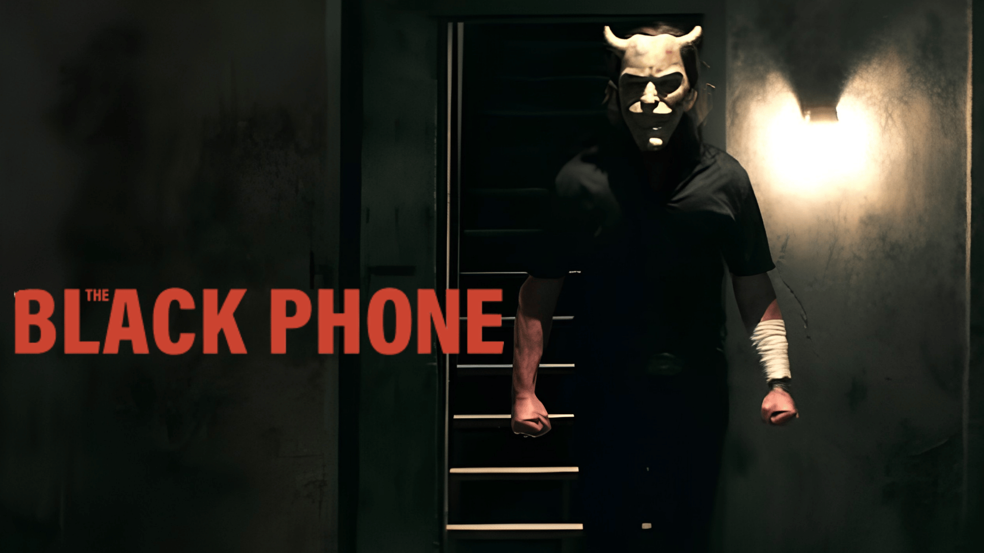 The Grabber stands in a dark hallway in The Black Phone, creating a chilling psychological horror scene.