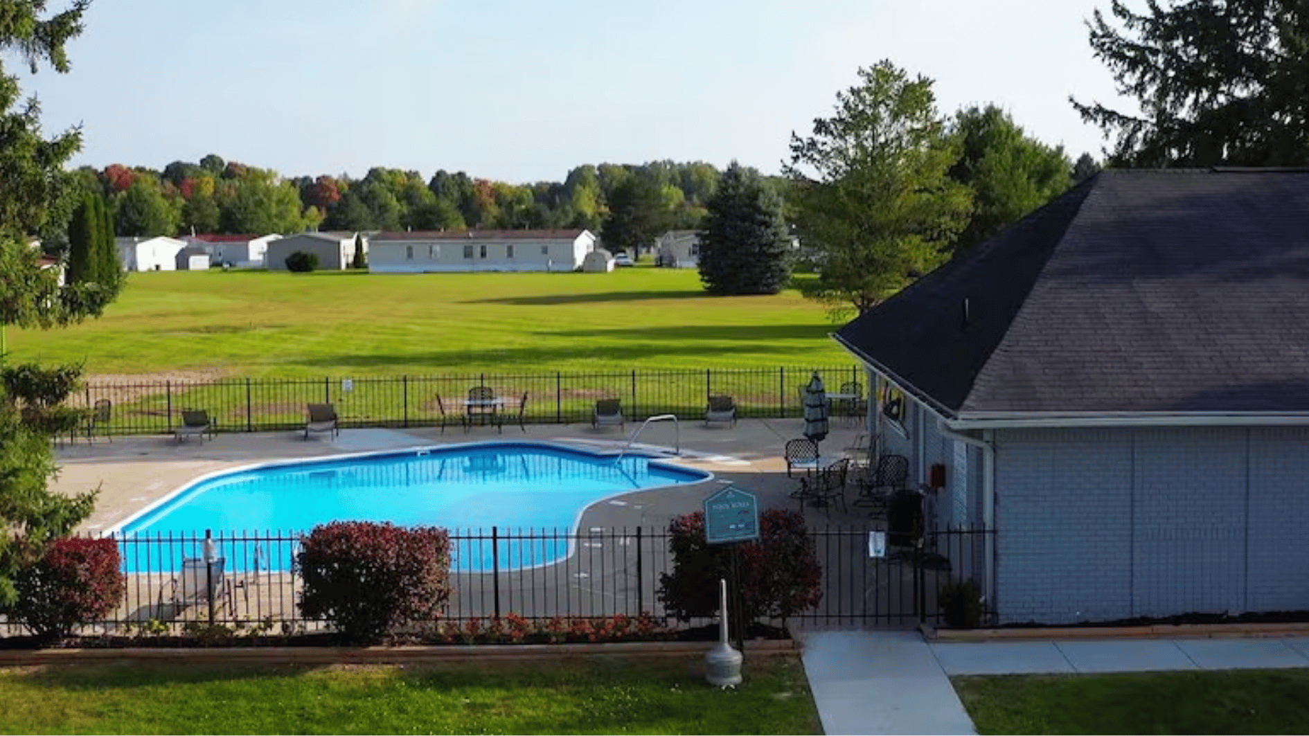 pineview estates community pool area showing outdoor amenities, landscaped grounds, and manufactured homes in the neighborhood setting