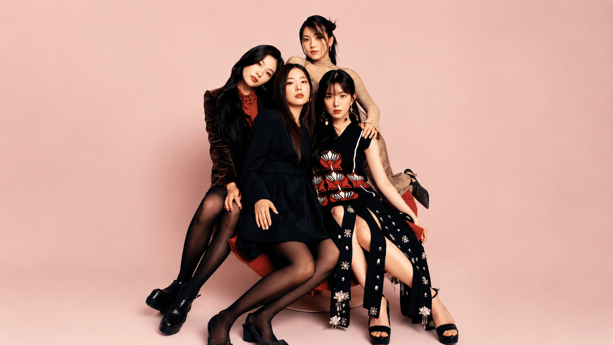 red velvet members posing in elegant black outfits on a pastel pink background