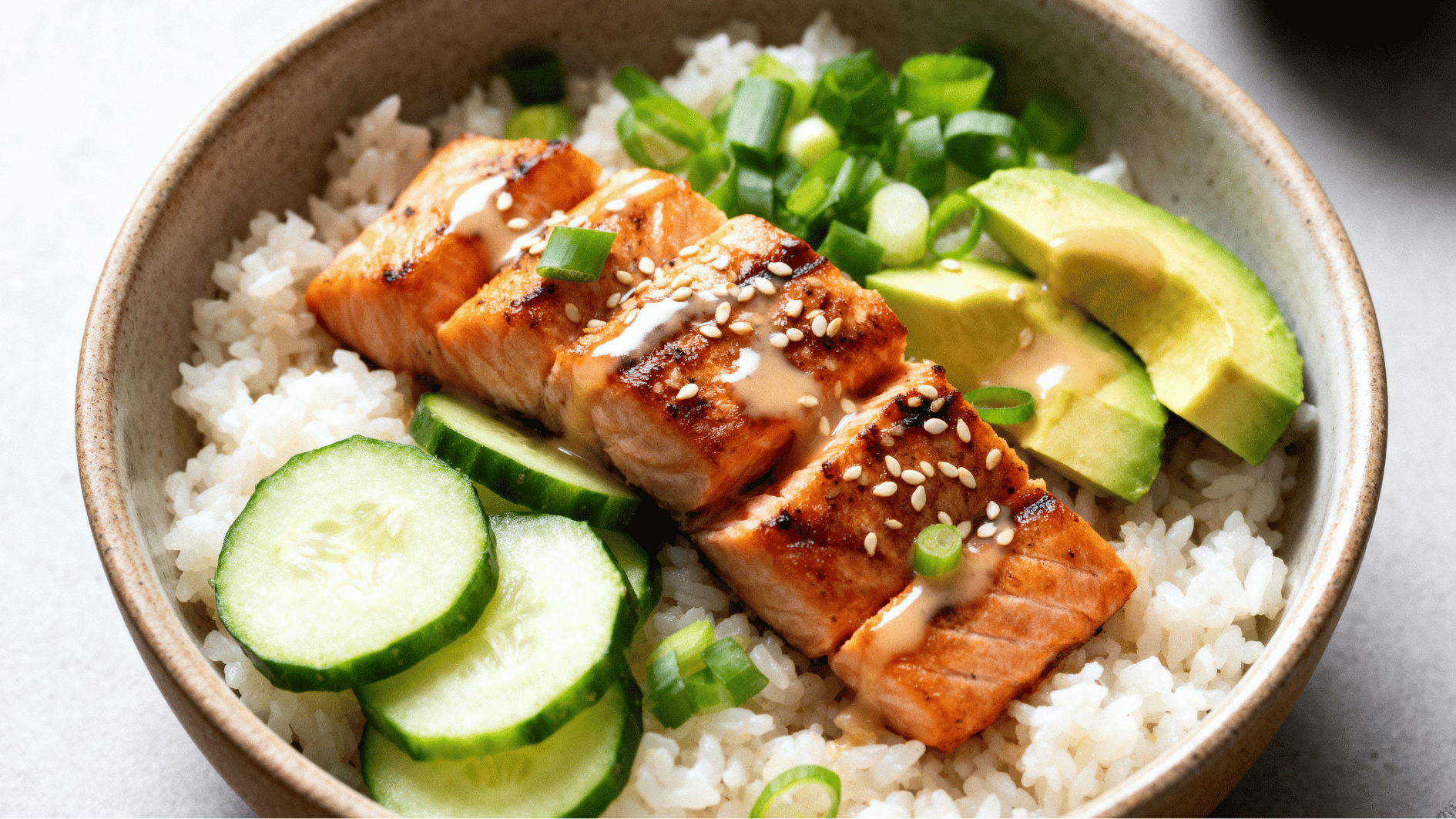 salmon rice bowl with grilled salmon rice avocado cucumber and fresh toppings served in a ceramic bowl for a healthy meal