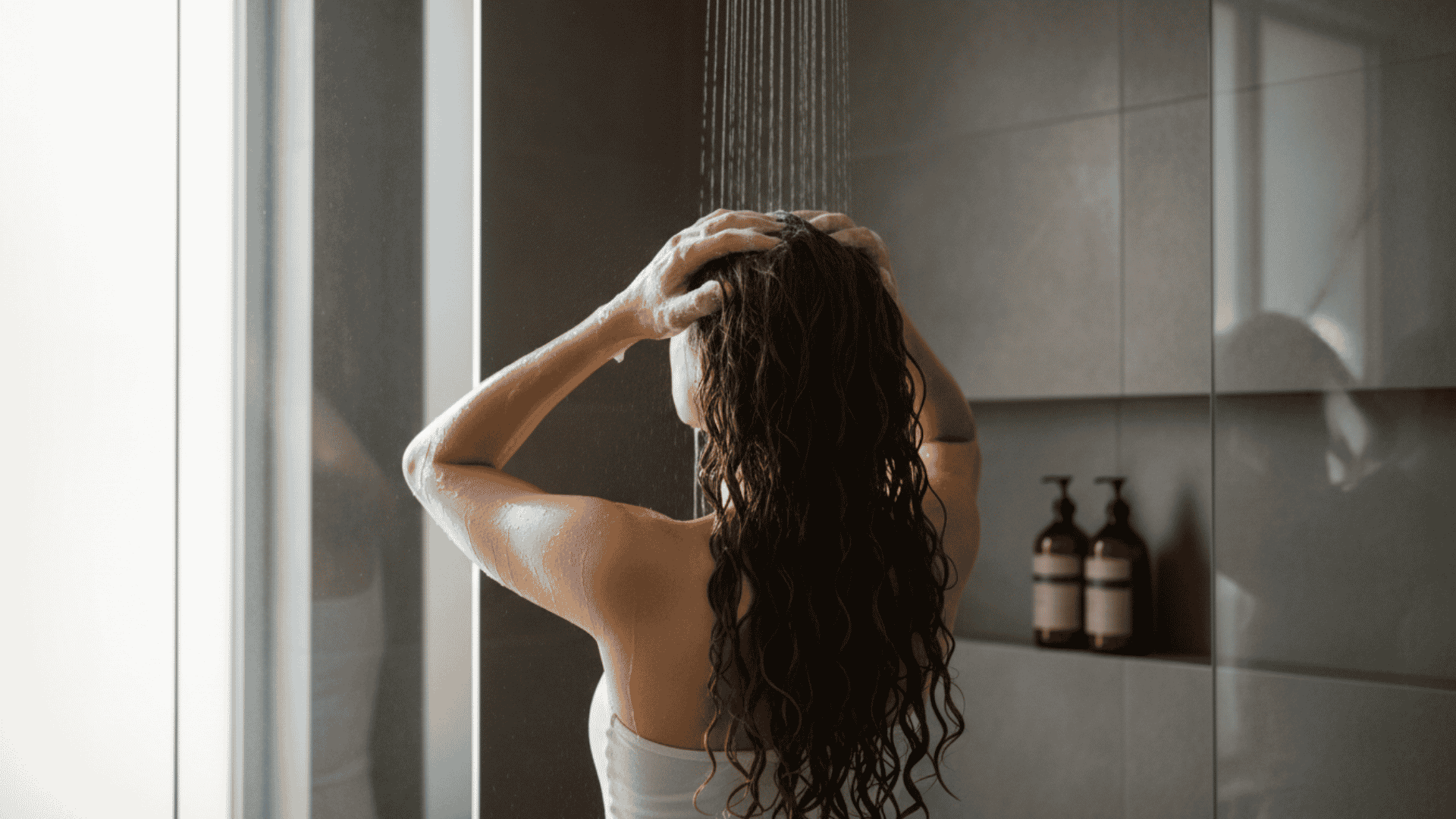 woman gently washing her naturally curly hair and massaging shampoo into her scalp