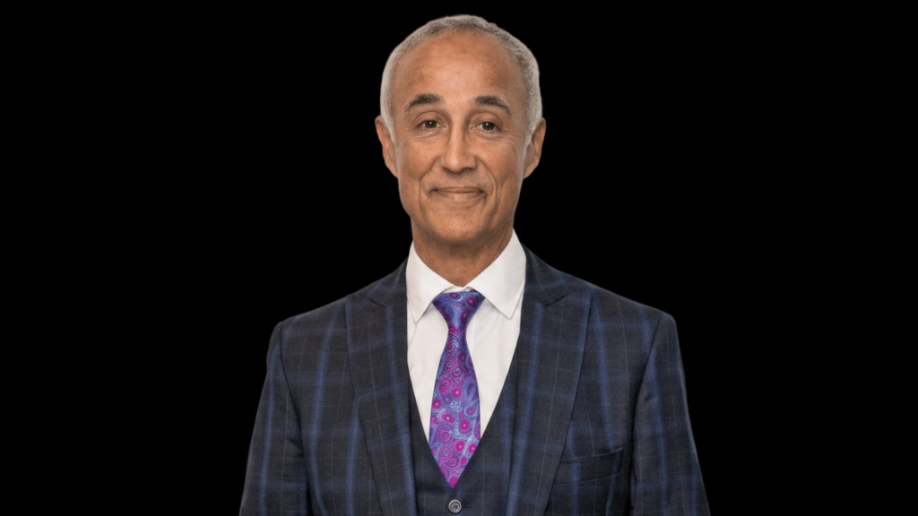 andrew ridgeley standing in front of black background.