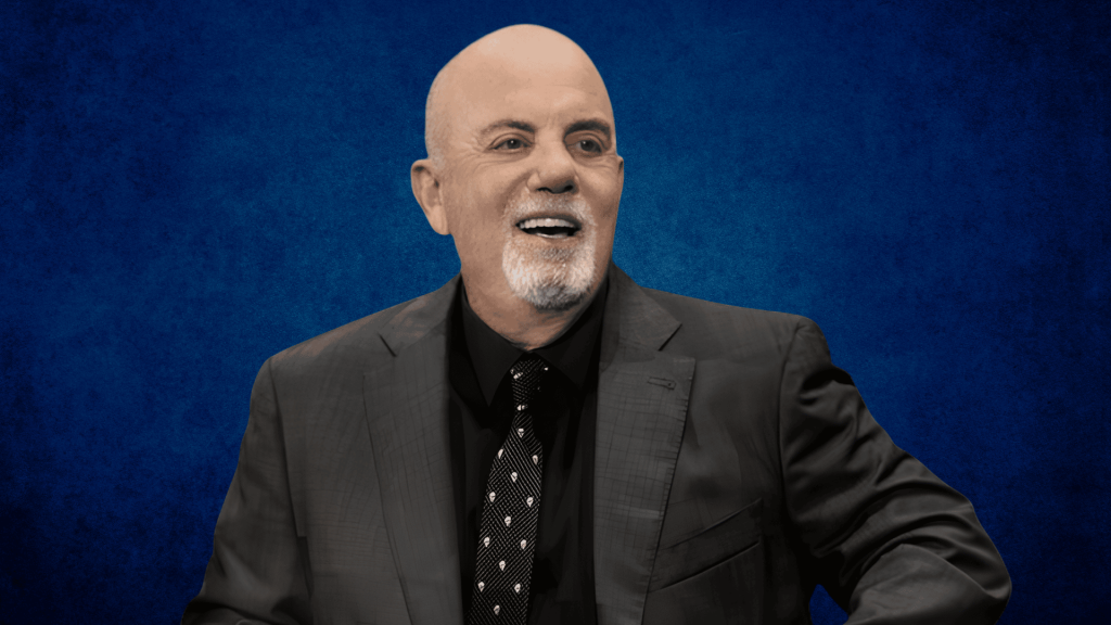 Billy Joel wearing a dark suit and patterned tie against a textured blue background