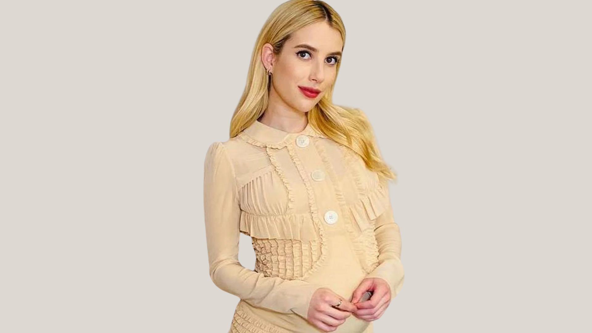 blonde woman in a ruffled beige button-up dress against a neutral background