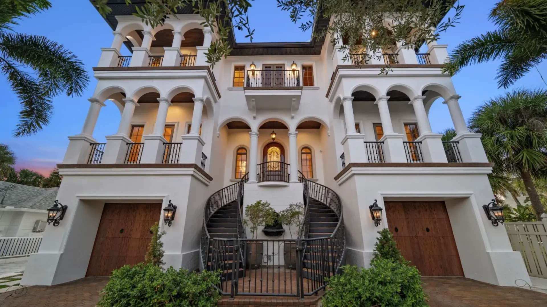hulk hogan clearwater beach mansion with white exterior balconies and palm trees near gulf