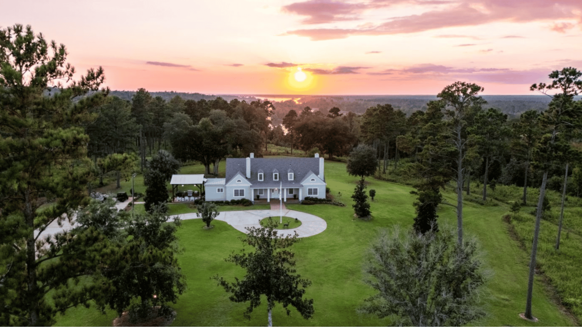 large private ranch property with a spacious home, green landscape, trees, and open acreage showing a rural estate setting