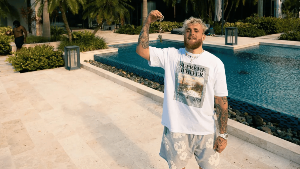 jake paul standing near a luxury pool area at his private property with outdoor landscaping and modern home features