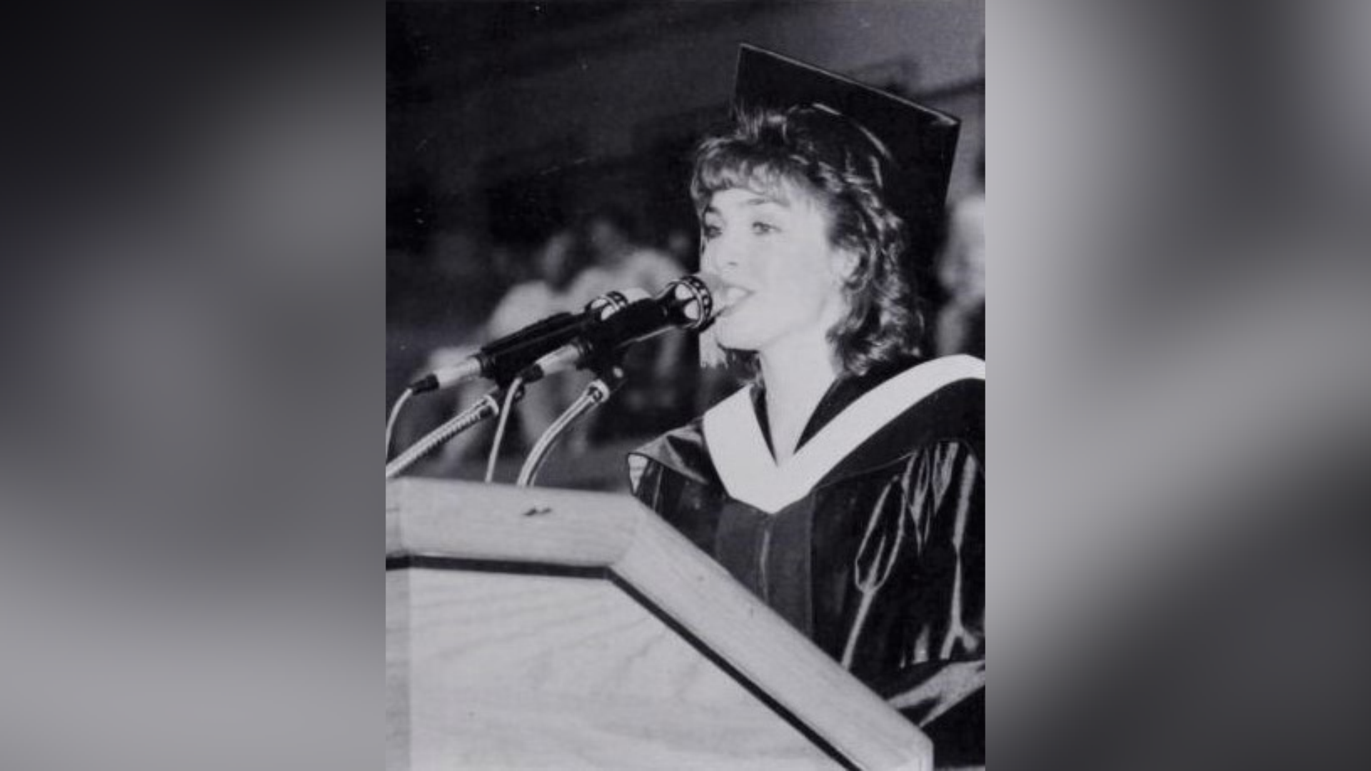 karen rogers speaking into microphones at a podium in a black and white archival photograph