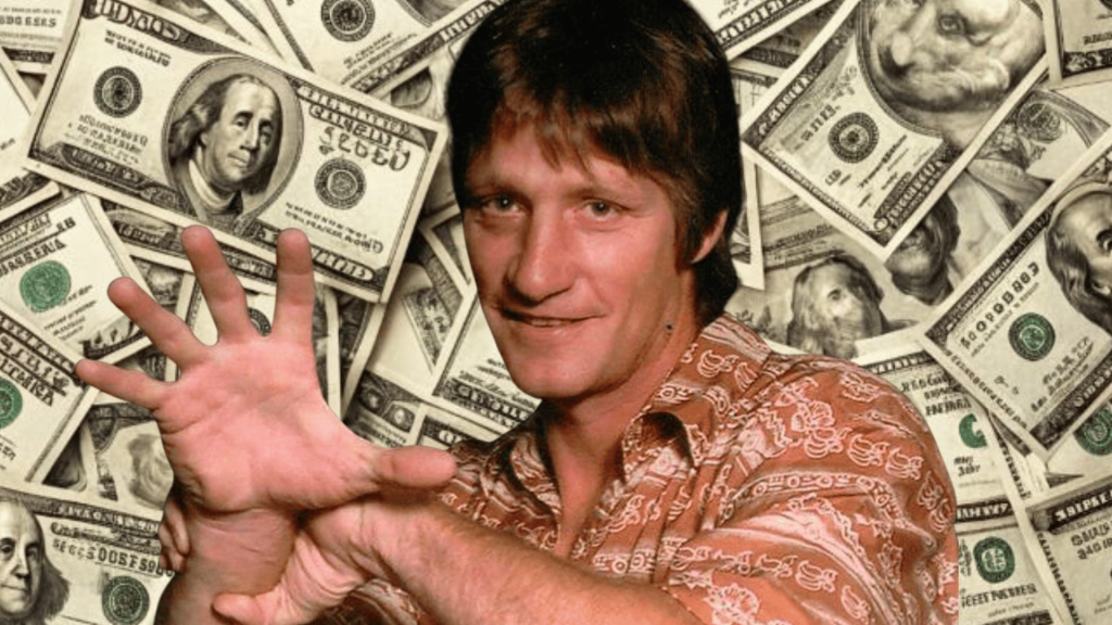 wrestler performing the iron claw hand gesture against a backdrop of money