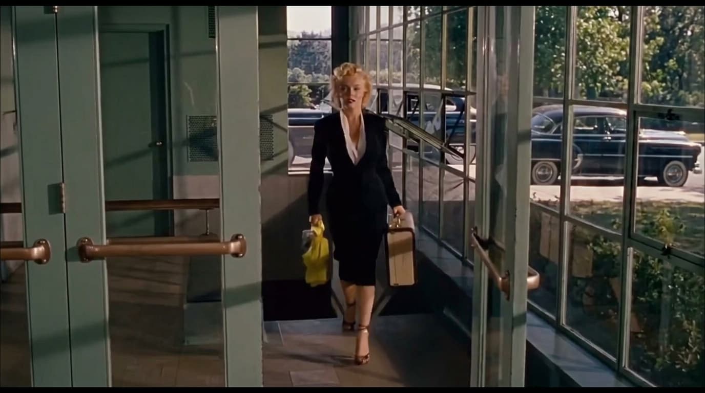 marilyn monroe walking indoors in a belted trench coat during a relaxed vintage off duty moment