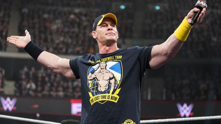 professional wrestler holding a microphone during a farewell tour in a wwe arena