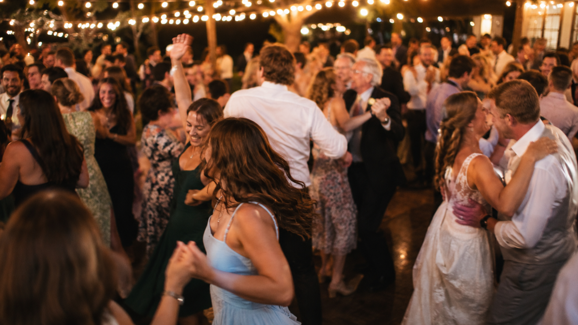 wedding guests dancing and celebrating on the reception dance floor