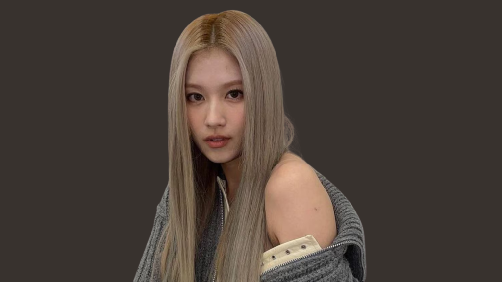 twice sana with long blonde hair wearing a gray outfit
