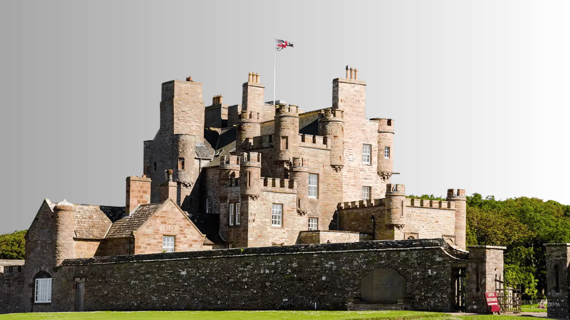 The Castle of Mey with stone towers, surrounding walls, and landscaped grounds in Scotland