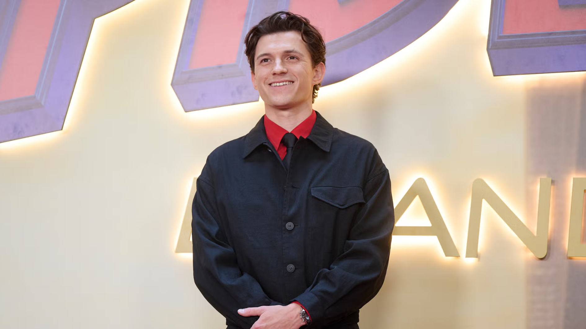 tom holland smiling at a film premiere
