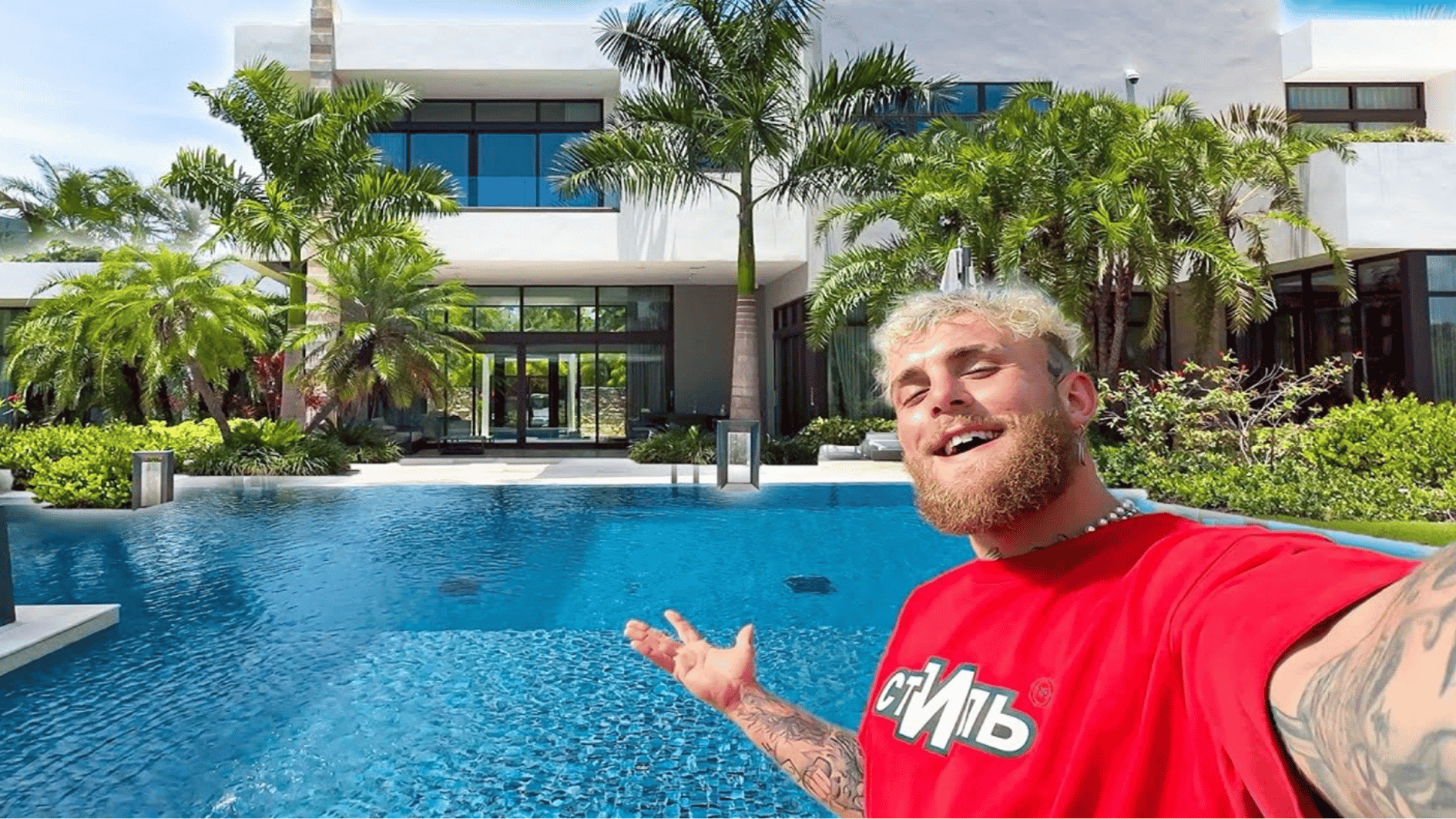 jake paul posing near a luxury pool with a modern home exterior and landscaped outdoor area at private property