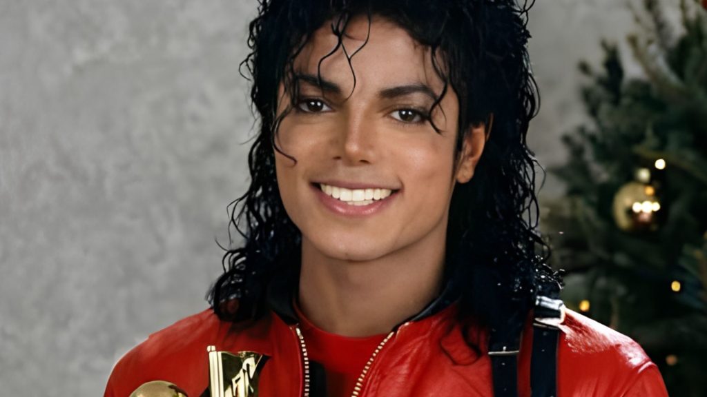 Michael Jackson smiling while wearing a red jacket in a decorated Christmas tree, giving the photo a warm and festive feel.