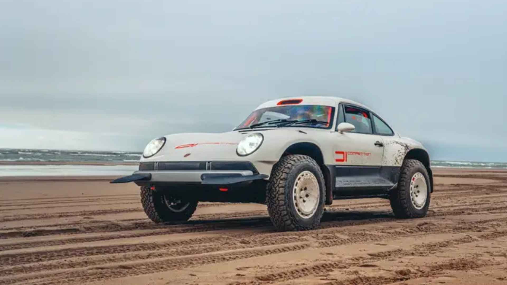 Singer ACS off-road Porsche 911 on a sandy beach with lifted suspension and rugged all-terrain tires