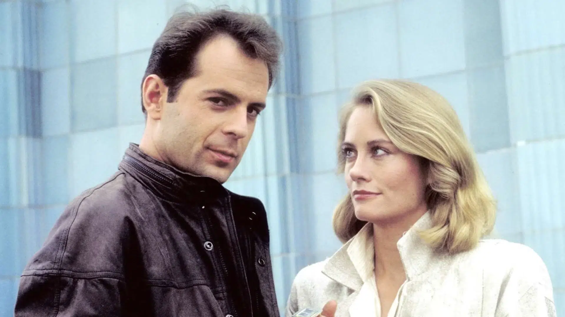 bruce willis standing beside a female co-star in a scene from a film with a blue background