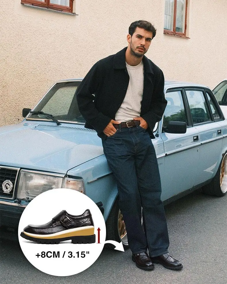 Man leaning on light blue vintage car wearing casual jacket and jeans in outdoor setting