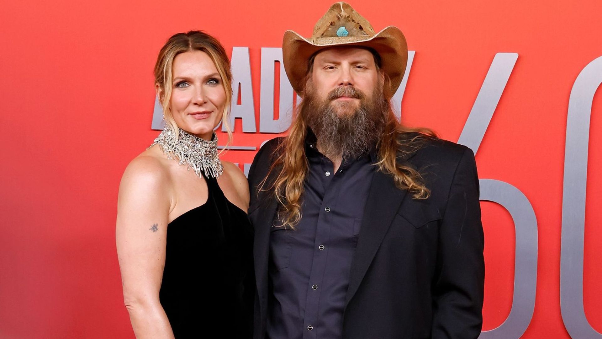 Chris Stapleton posing with his wife at a public event