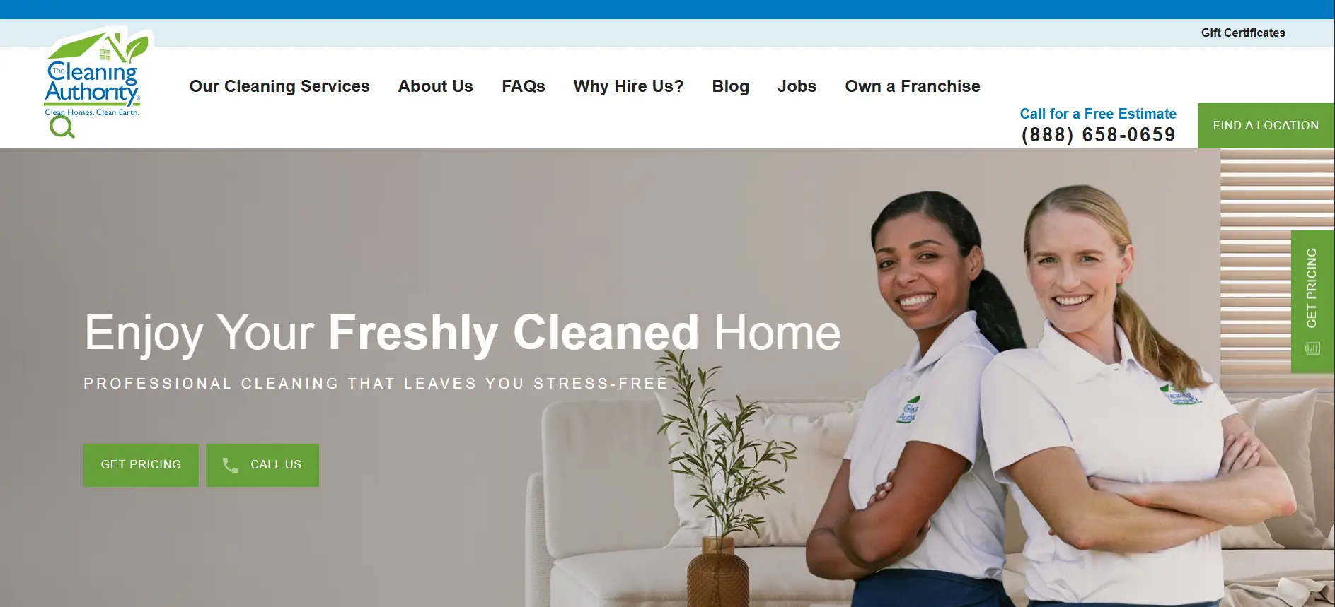 Two smiling women in branded polo shirts standing indoors next to a beige couch and potted plant