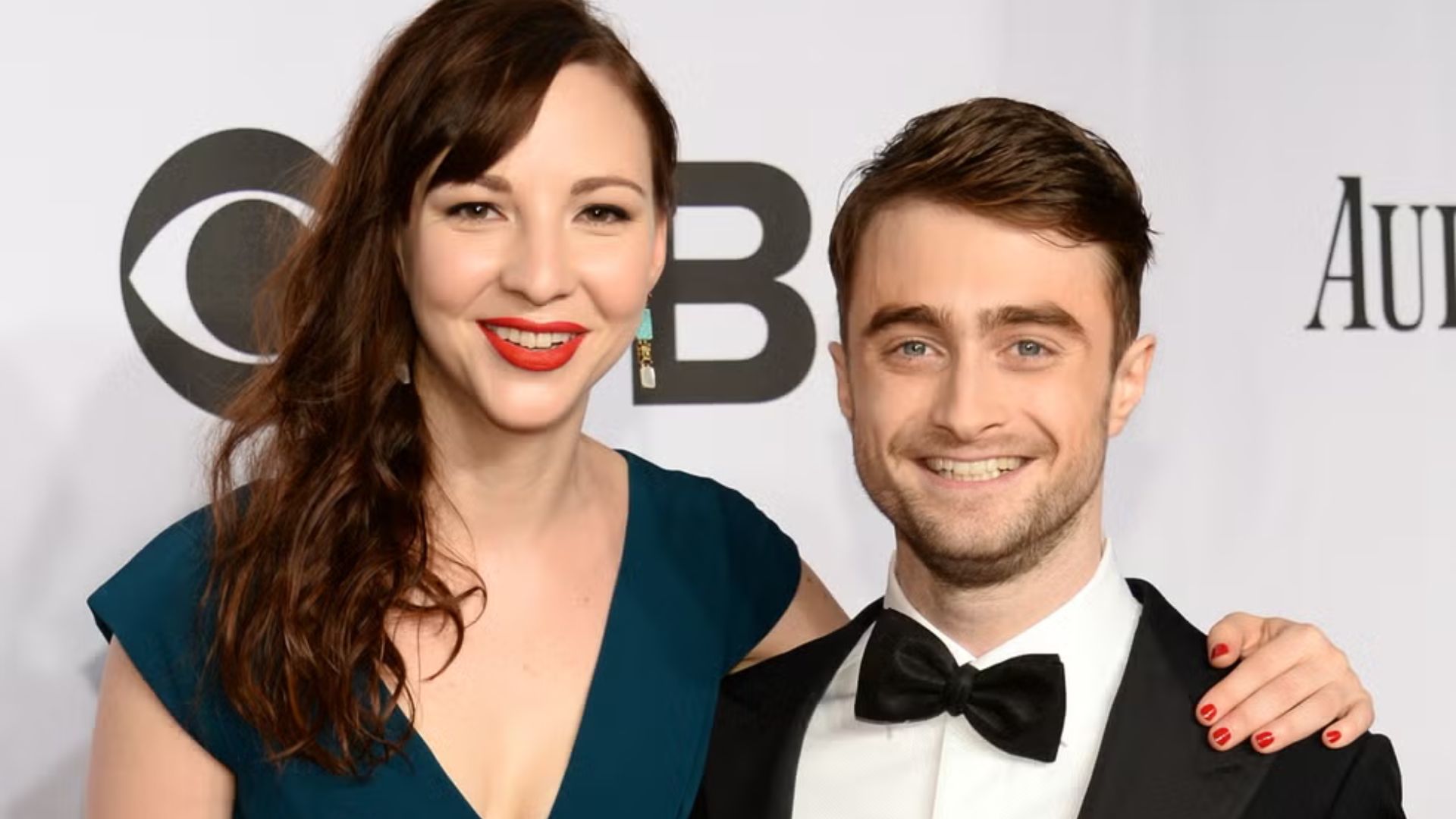 Daniel Radcliffe posing with Erin Darke at a formal event