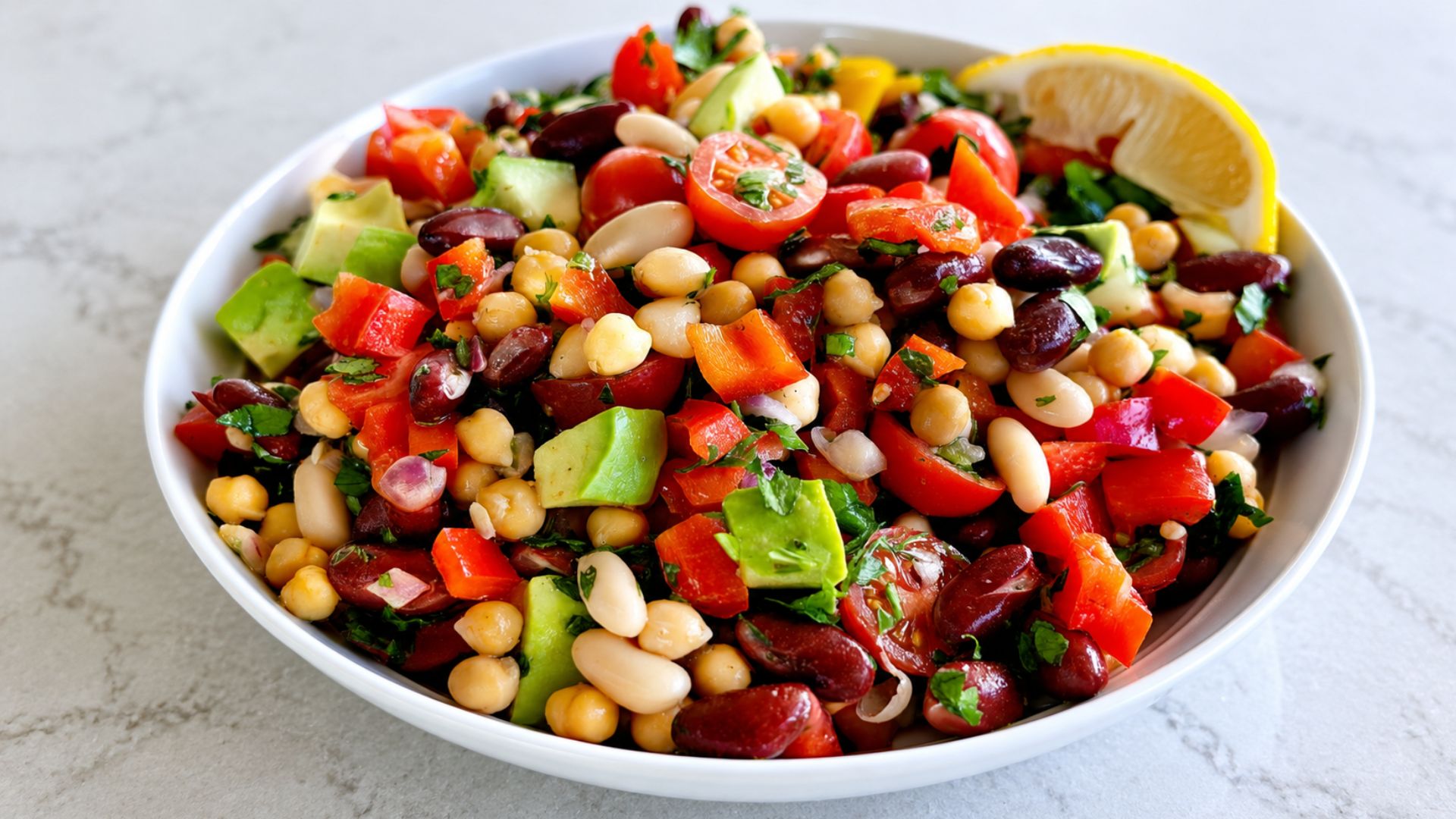 Dense bean salad with chickpeas, white beans, kidney beans, cucumber, peppers and fresh parsley.