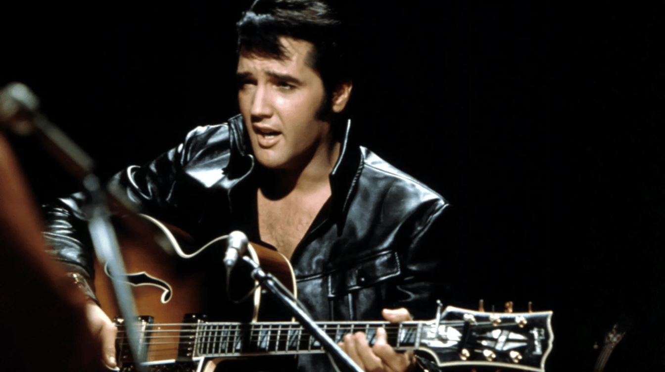 elvis presley singing into a microphone while playing guitar on stage