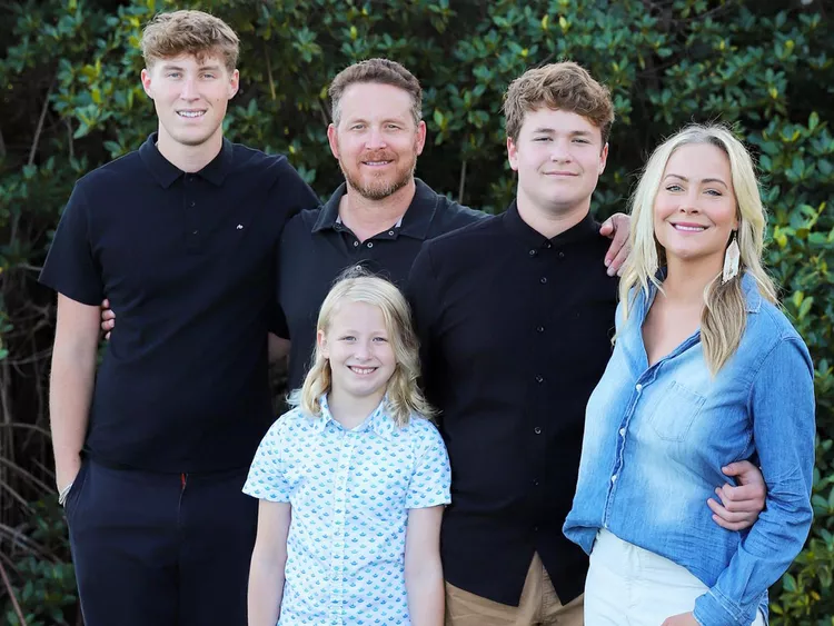 actor cole hauser posing with family members outdoors in a casual group portrait with greenery background