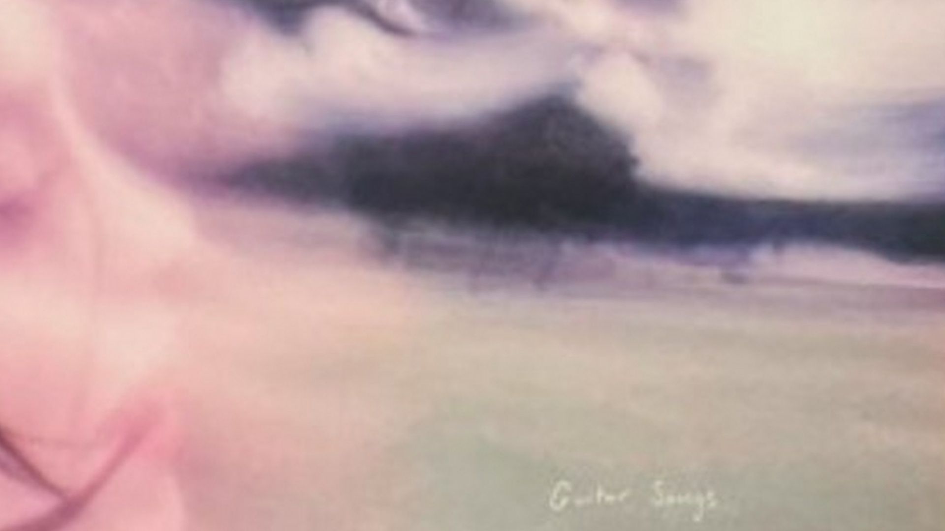 Cover artwork for Billie Eilish’s“Guitar Songs,” featuring a blurry, dreamlike landscape of a green field under a cloudy sky with the faint profile of a face on the left.