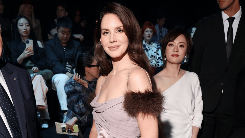 Lana Del Rey in a soft lavender off-the-shoulder gown accented with brown fur trim while attending the Maison Valentino Spring/Summer 2026 show during Paris Fashion Week
