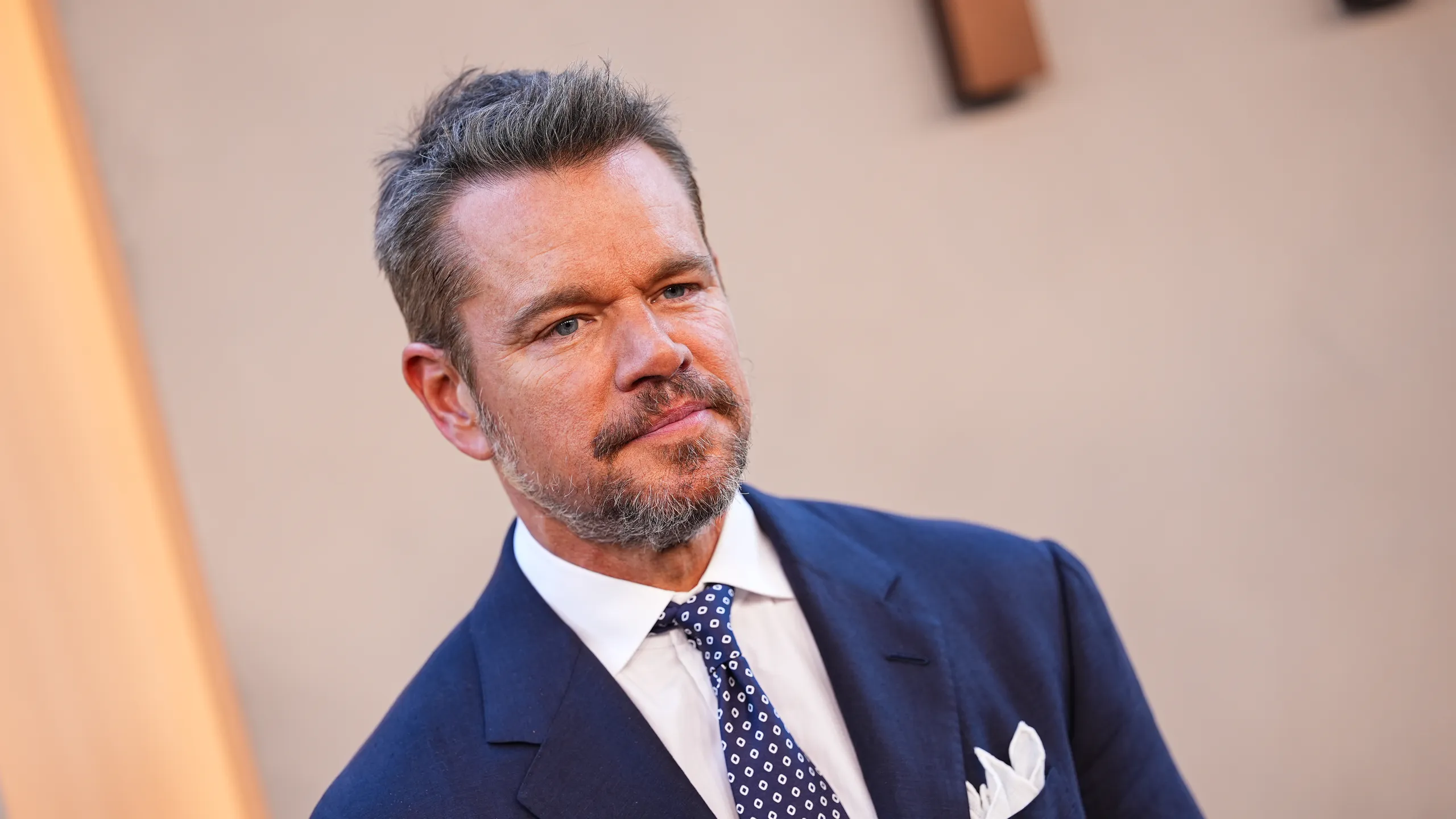 matt damon wearing a navy suit and tie at a formal event