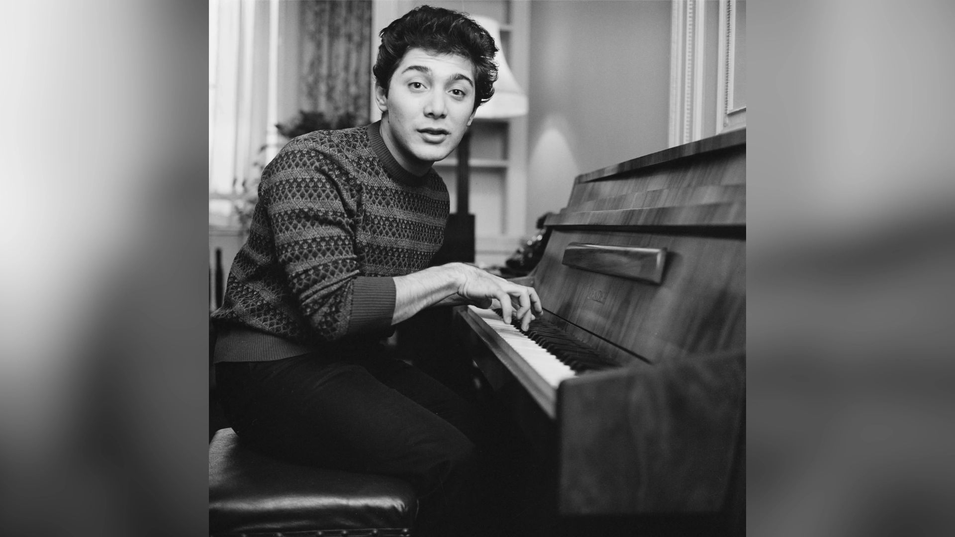 young paul anka sitting at a piano during his early music career in black and white photo