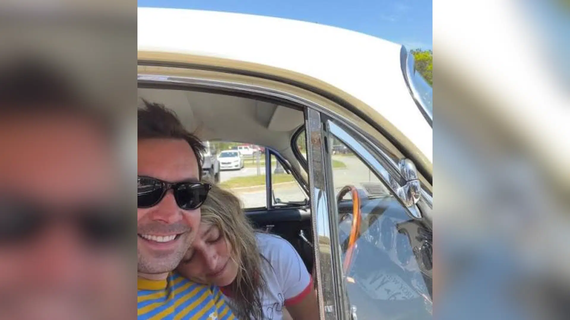 man and woman smiling together in a vintage car during an outdoor daytime outing