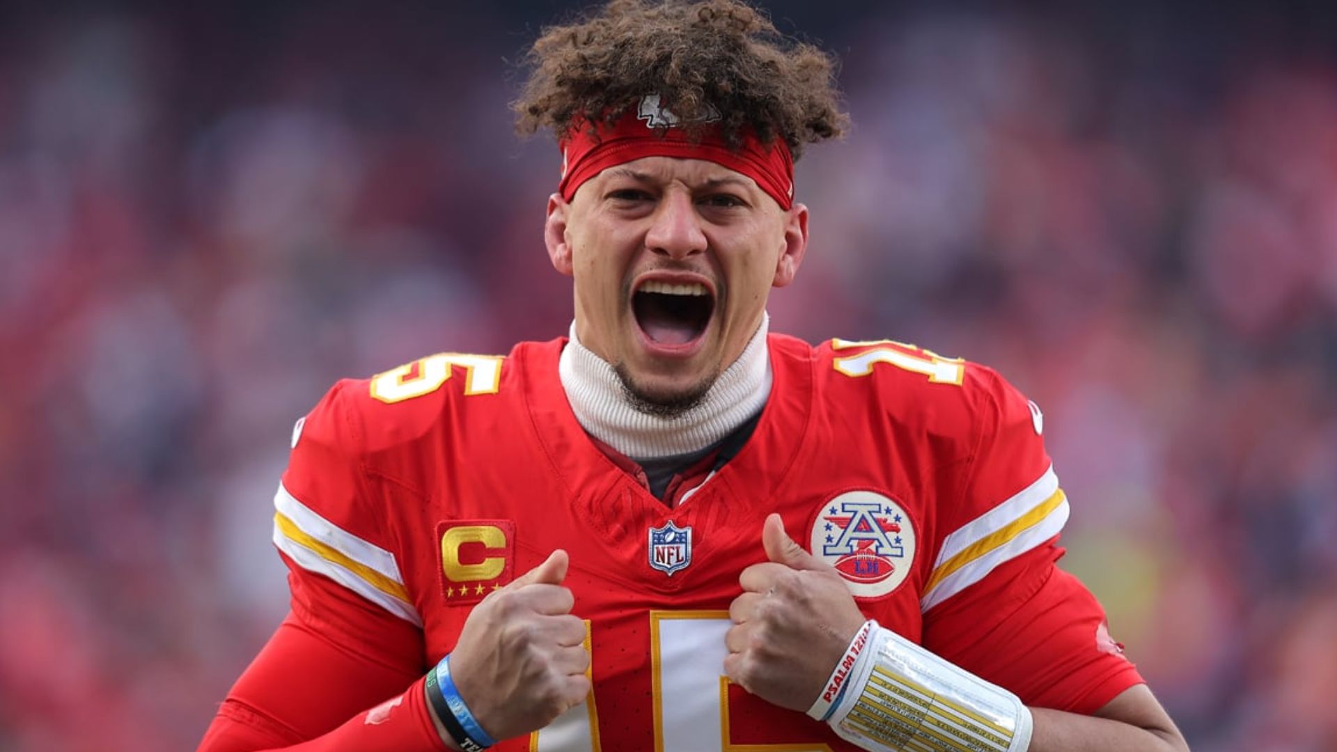 Patrick Mahomes wearing a Chiefs uniform during a game while celebrating a play on the field.