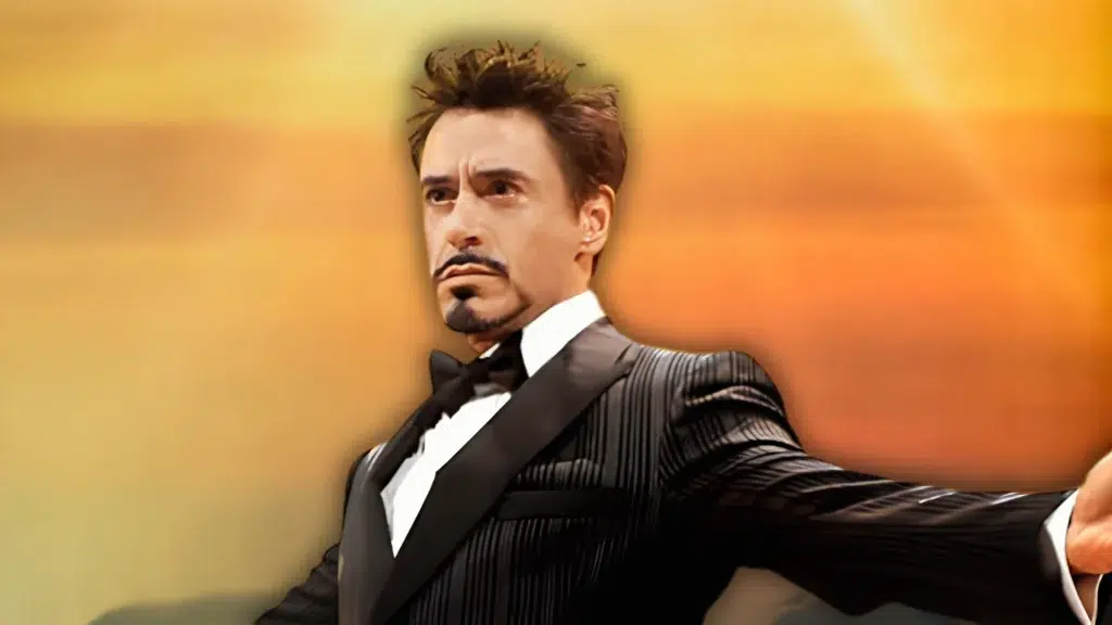 robert downey jr in a formal black tuxedo portrait with a warm golden background for net worth article