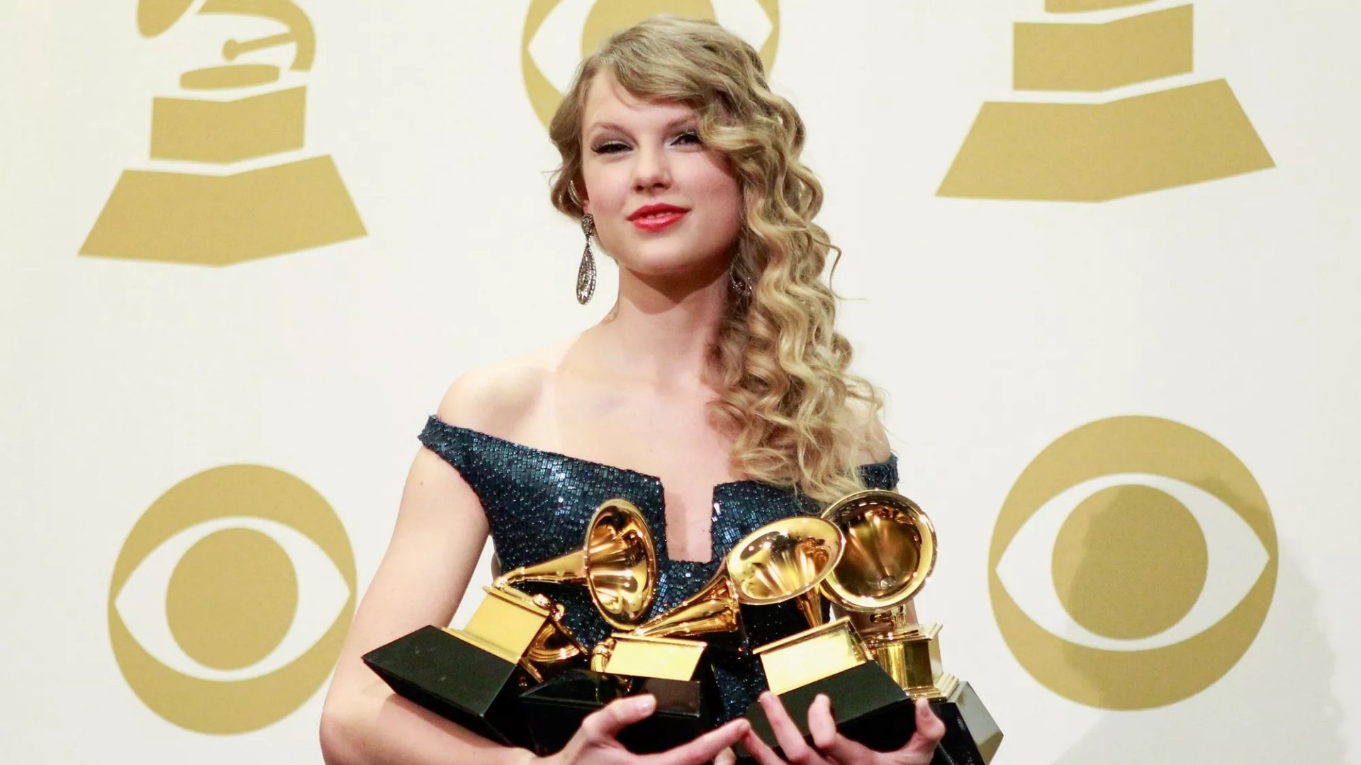 Taylor Swift posing in the press room with her four Grammy Awards during the 52nd Annual Grammy Awards