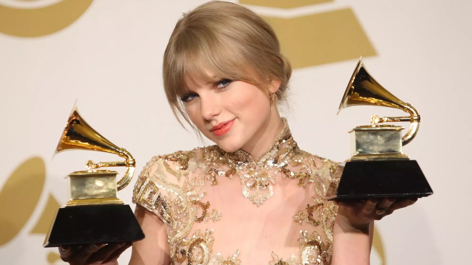 Taylor Swift holding her two Grammy Awards backstage at the 54th Annual Grammy Awards