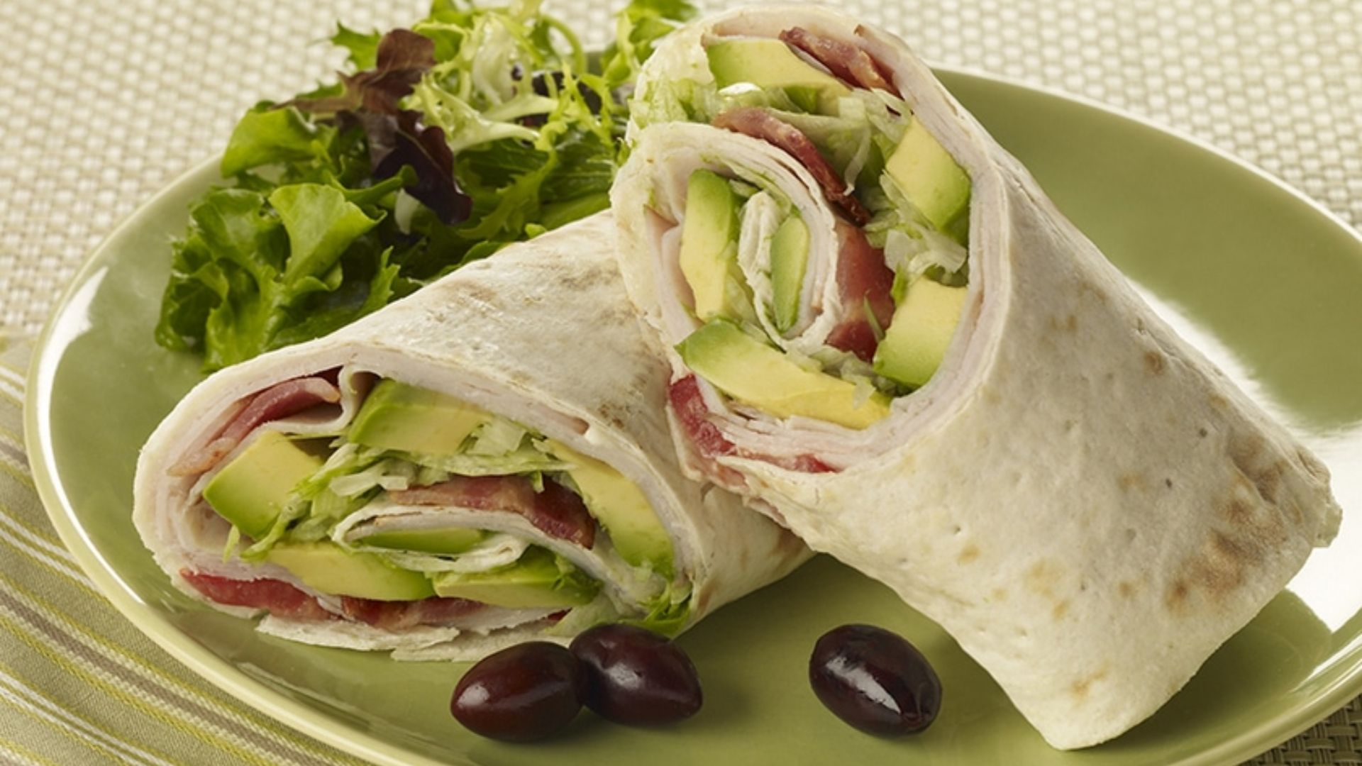 Turkey avocado wrap filled with sliced turkey, avocado, lettuce, tomato and cucumber.
