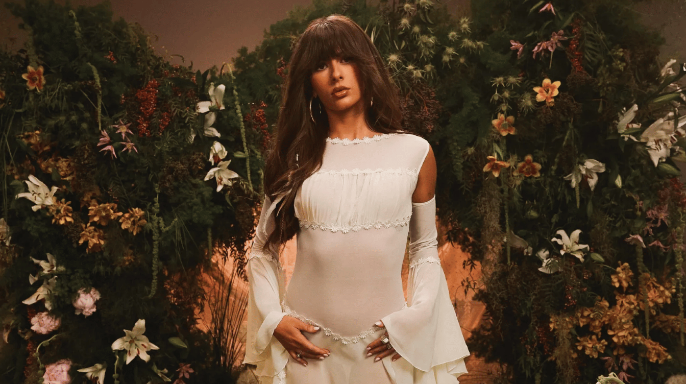 ella langley wearing a white dress during a floral music video photoshoot