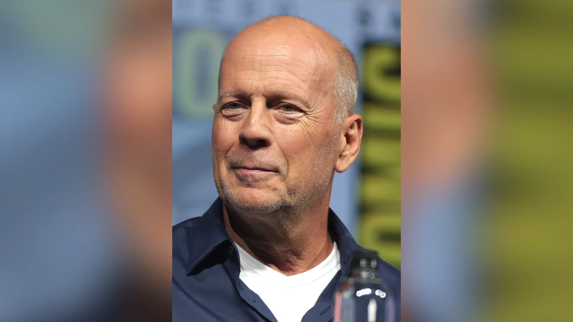bruce willis portrait wearing a dark shirt during a public appearance with blurred background