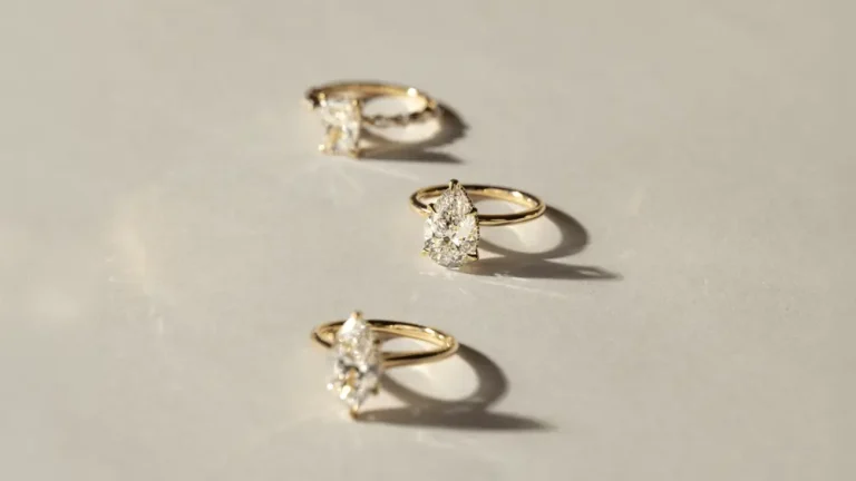 Gold rings with diamond stones casting shadows on a textured surface in soft lighting