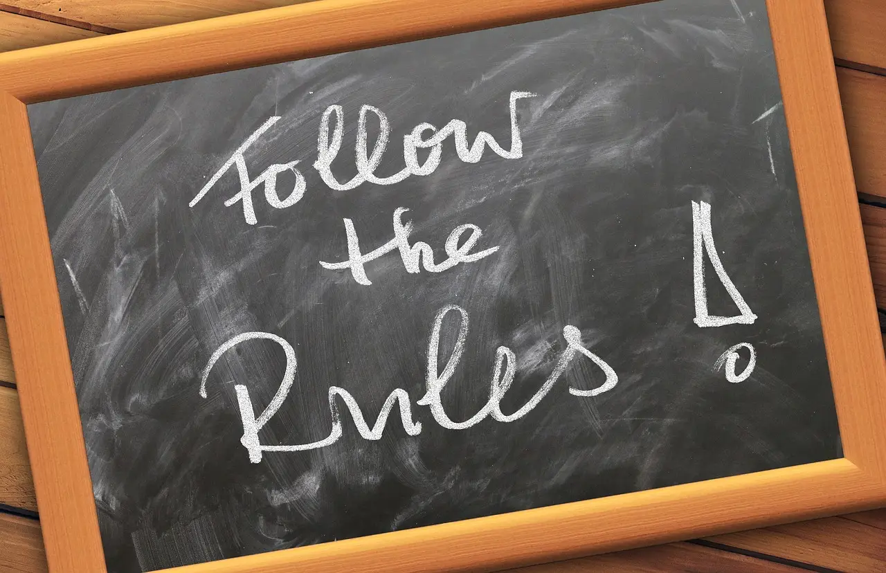 Chalkboard with phrase "Follow the Rules" written in white chalk