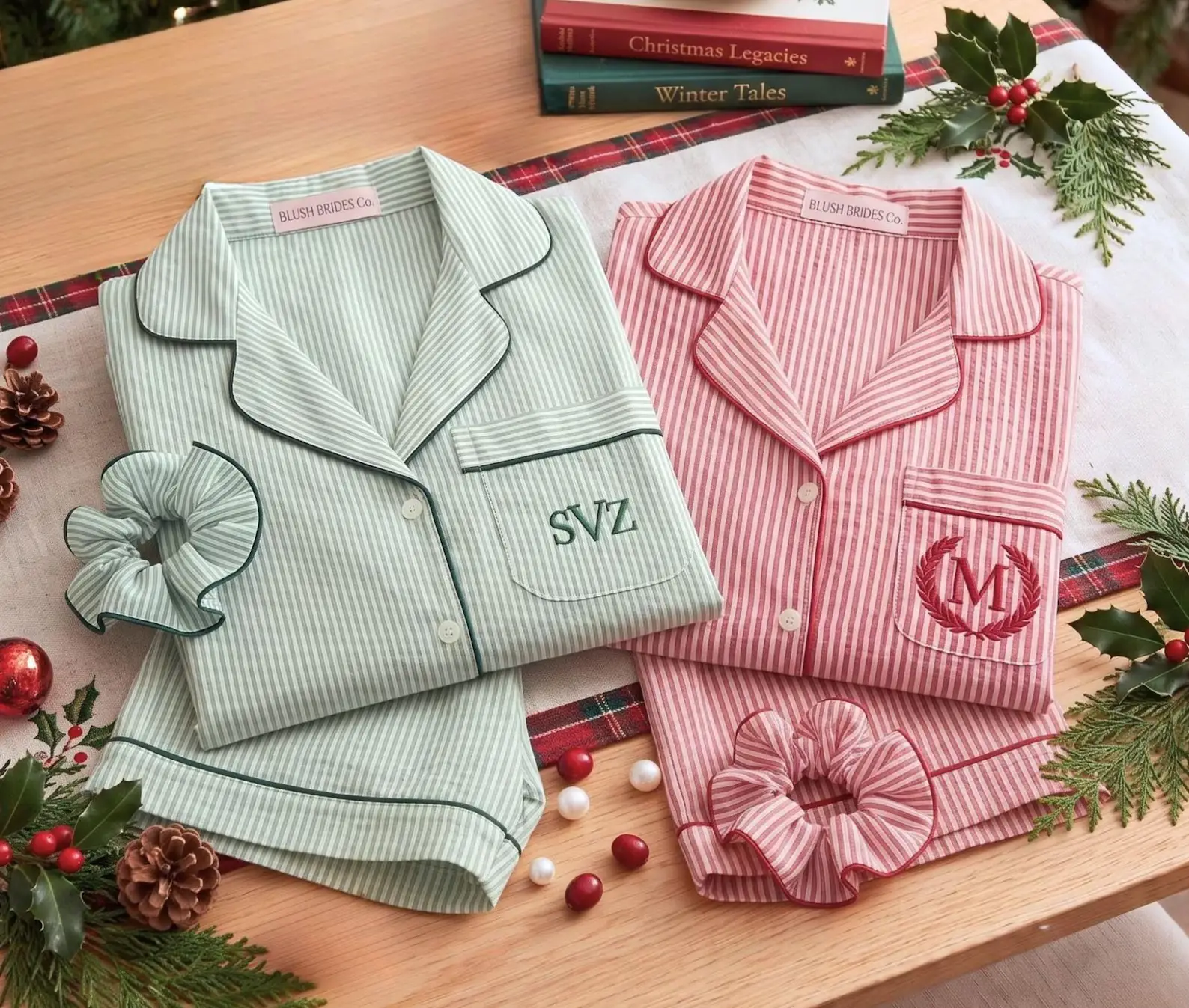 Striped red and green pajamas with monograms on wooden table surrounded by holiday decorations
