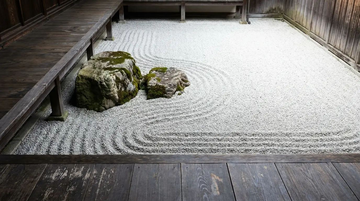 Japanese Zen garden with raked gravel patterns and moss-covered rocks in wooden courtyard setting